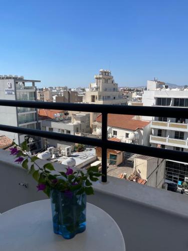 a vase with flowers sitting on a table on a balcony at Krasas Beach in Larnaka
