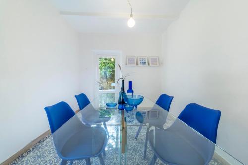 ein Esszimmer mit einem Glastisch und blauen Stühlen in der Unterkunft Memory Atelier - apartment in Florence in Florenz
