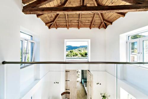 una camera con pareti e finestre bianche e pavimento in vetro di Manto Retreat in Nature a Págoi