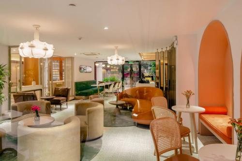 a lobby with couches and tables and chairs at Hanoi Le Jardin Hotel & Spa in Hanoi