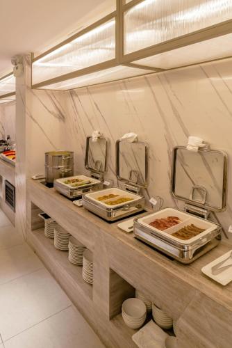 a kitchen with several trays of food on a counter at Hanoi Le Jardin Hotel & Spa in Hanoi