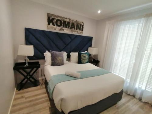 Modern Seaview Apartment في Summerstrand: غرفة نوم مع سرير كبير مع اللوح الأمامي الأزرق