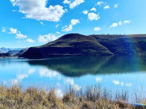 - une vue sur une montagne réfléchissant dans un lac dans l'établissement Valley Lakes THE LODGE, à Underberg