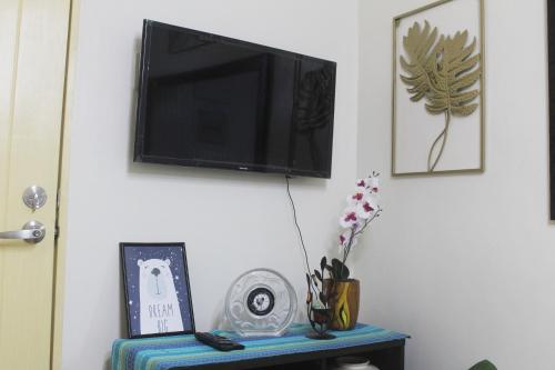 a flat screen tv hanging on a wall with a table at 4th- Sea View of Seawind Condominium in Davao City