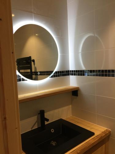 une salle de bain avec un lavabo noir et un miroir dans l'établissement Appartement Bois Colombes Châtel Réservation, à Châtel