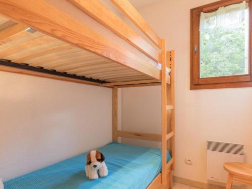 un chien jouet assis sur un lit dans une chambre dans l'établissement Charmant 2 pièces, 4 couchages avec garage- Serre Chevalier, Chantemerle. - FR-1-330E-94, à Saint-Chaffrey