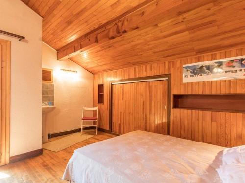 une chambre avec un lit et un mur en bois dans l'établissement Chalet spacieux 8 pers. avec cheminée et TV à Serre-Chevalier, Chantemerle - FR-1-330E-19, à Saint-Chaffrey