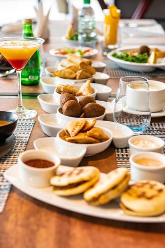 a long table with plates of food and a drink at Swiss-Belsuites Admiral Juffair in Manama