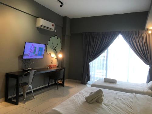 a bedroom with a bed and a desk with a computer at Aeropod Sovo-Star Suite in Kota Kinabalu