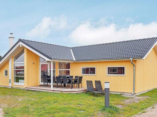 a yellow house with a table and chairs at 10 person holiday home in Gro enbrode in Großenbrode