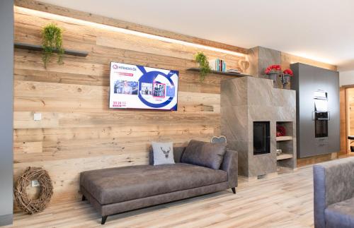 a living room with a couch and a wall at AvenidA Style Appartements by Alpin Rentals - incl Summercard in Kaprun