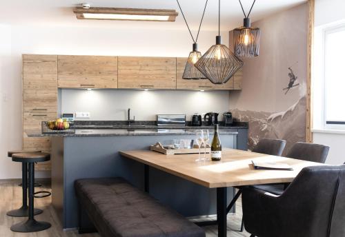 a kitchen with a wooden table and a counter at AvenidA Style Appartements by Alpin Rentals in Kaprun