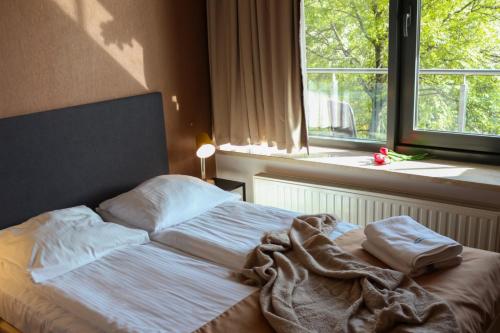 uma cama não feita num quarto com uma janela em VisitZakopane - Cristal Apartment em Zakopane