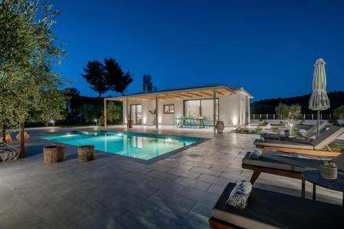 a backyard with a swimming pool and a house at Tsilivi Pandessia Villa in Tsilivi
