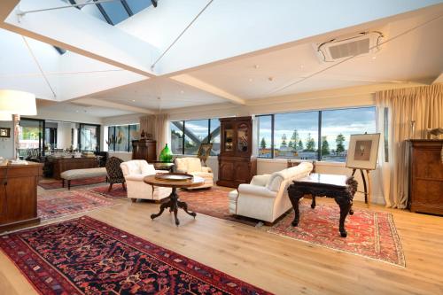 a living room filled with furniture and a piano at The Address - Luxury 3 Bedroom Penthouse Apartment in Napier