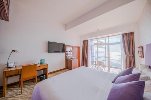 Cette chambre comprend un lit, un bureau et une fenêtre. dans l'établissement Hotel Novotel Nha Trang, à Nha Trang