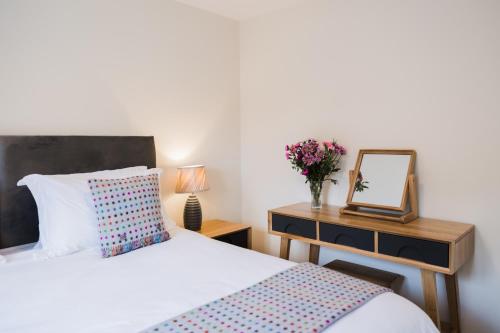 a bedroom with a bed and a dresser with a mirror at College Court in Bedale