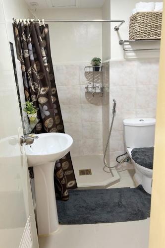 a bathroom with a shower with a sink and a toilet at 4th- Sea View of Seawind Condominium in Davao City