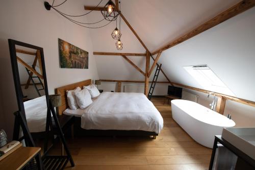 ein Schlafzimmer mit 2 Betten und einer Badewanne darin in der Unterkunft Boutique Hotel d'Oude Morsch in Leiden