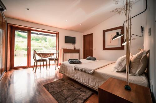 a bedroom with a bed and a dining room with a table at Casa da Várzea - Serra da Estrela in Fornos de Algodres