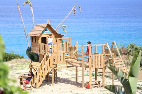 three people in a wooden play house on the beach at Borgo Donna Canfora in Capo Vaticano