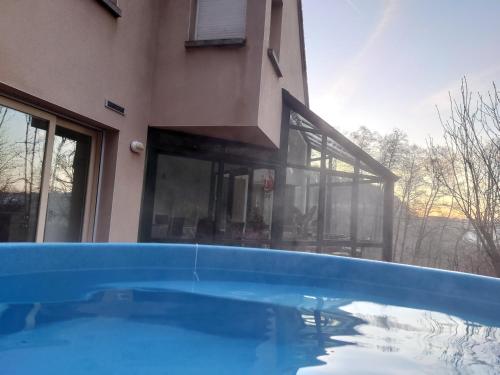 a house with a swimming pool in front of a building at Villa pré d'Oro - 1000 étangs in Amage
