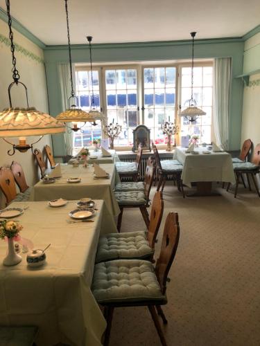 a dining room with tables and chairs and windows at Hotel Alt N&uuml;rnberg in Hamburg