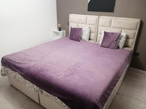 a large bed with purple sheets and pillows at Golden Sunset in Njivice