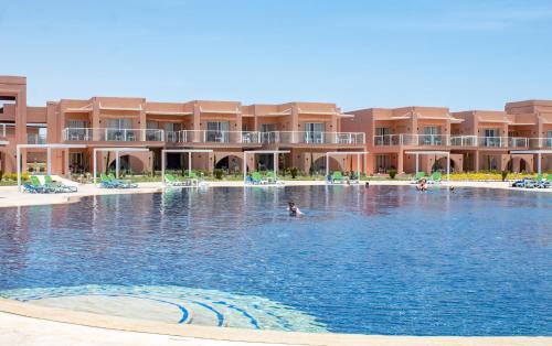 a swimming pool in front of a resort at Neverland City Hurghada - Pickalbatros in Hurghada