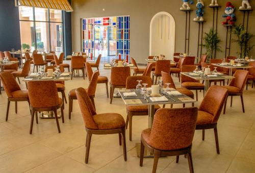 a restaurant with tables and chairs in a room at Neverland City Hurghada - Pickalbatros in Hurghada