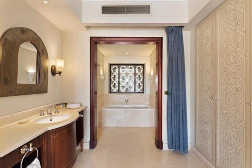a bathroom with a sink and a tub and a window at Pickalbatros The Palace Port Ghalib in Port Ghalib