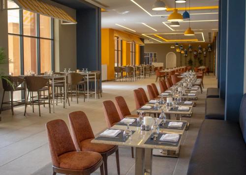 a row of tables and chairs in a restaurant at Neverland City Hurghada - Pickalbatros in Hurghada