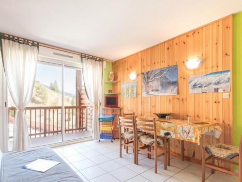 une salle à manger avec une table et un balcon dans l'établissement Appartement cosy 4 pers à Chantemerle avec balcon, parking, proche pistes de Serre-Chevalier! - FR-1-330E-12, à Saint-Chaffrey
