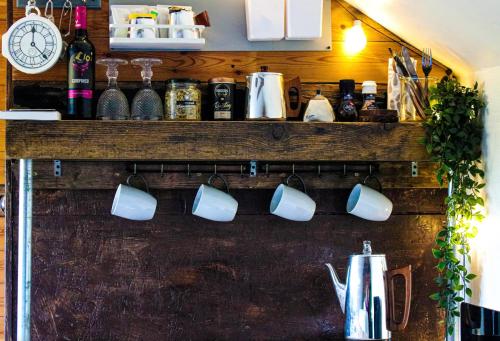 a counter with mugs hanging on a wall at The Stable Annexe & Spa in Dogdyke