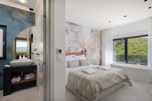 una camera con letto king-size e lavandino di Luxury Villa Arya with 77sqm heated pool, hot-tub, sauna, gym, billiard, playgrounds, 6 bedroom a Bajagić