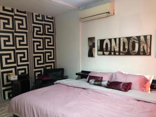 a bedroom with a bed and a black and white wall at Serenity plus in Accra