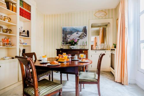 une salle à manger avec une table et des chaises en bois dans l'établissement Saint-Germain Prestige Residence, à Paris