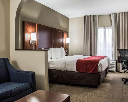 a hotel room with a bed and a couch at Comfort Suites Research Park - University in Charlotte