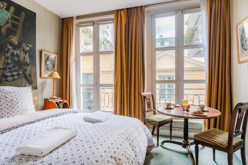 une chambre avec un lit, une table et une fenêtre dans l'établissement Saint-Germain Prestige Residence, à Paris