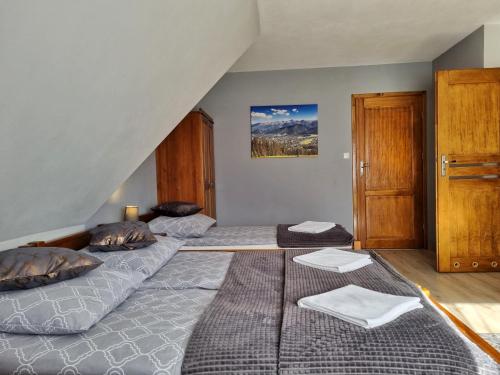 a bedroom with two beds and a staircase at Pokoje u Hani - sauna, balia z hydromasażem in Bukowina Tatrzańska