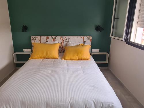 - un lit avec 2 oreillers jaunes dans l'établissement Dlalate, à Agadir
