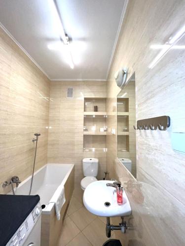 a bathroom with a sink and a tub and a toilet at Apartamenty Wałowa 7a - ap. Kompaktowy in Łańcut