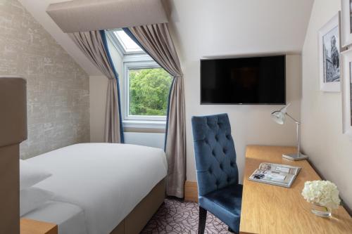 a hotel room with a bed and a chair and a desk at The Scholar in Edinburgh