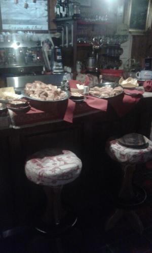 a group of stools with a table with food at Hotel Etoile De Neige in Valtournenche