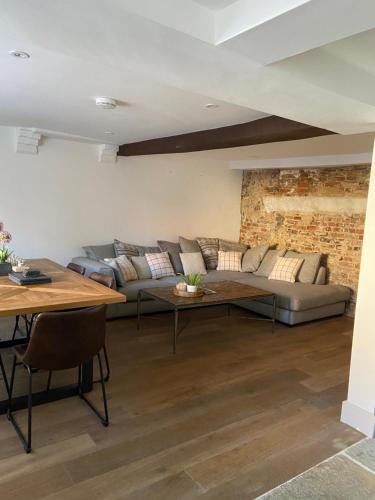 a living room with a couch and a table at Grade II Listed 3 Bedroom Cottage With Free Parking in King's Lynn