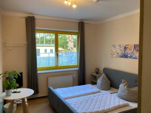 a bedroom with a blue bed and a window at Erholungs- und Freizeithaus Neu Sammit in Krakow am See