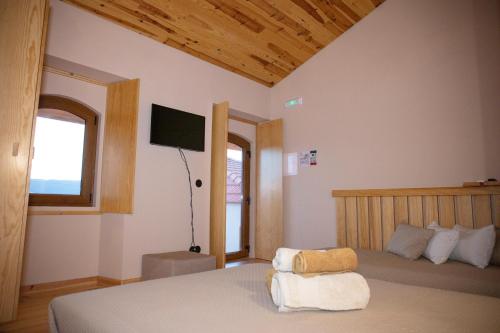 a bedroom with a bed and a flat screen tv at Vale das Maias - Casa de Campo in Laborins