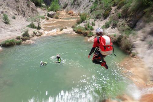 a man is standing in the water in a river at Càmping Organyà Park in Organyà