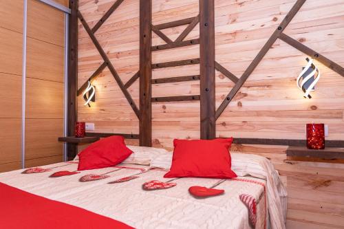 1 dormitorio con 1 cama con almohadas rojas en La Casona de Trescasas, en Sonsoto