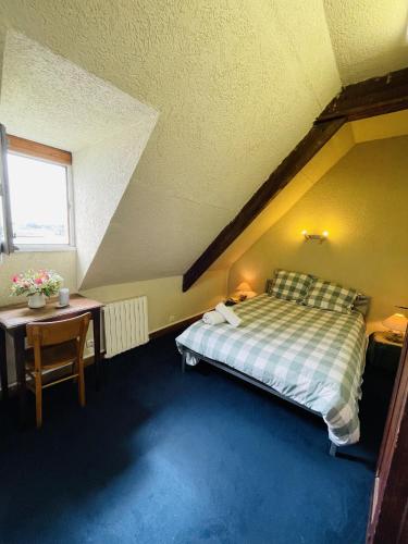 a bedroom with a bed and a table and a window at St Rom, Vue imprenable sur l'Ile de Bréhat in Bréhat